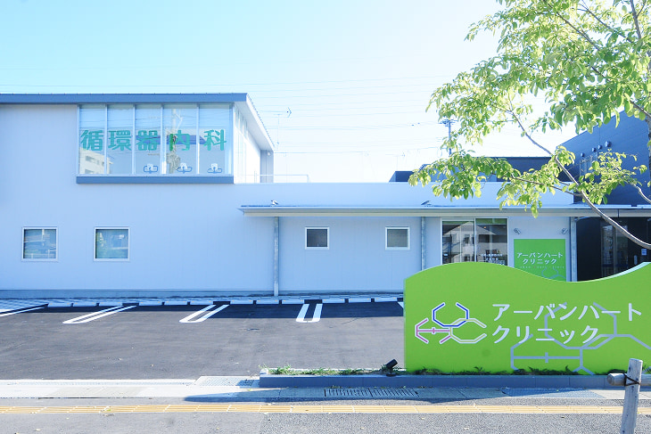 福岡市西区今宿にある循環器内科・一般内科・メディカルフィットネス（心臓リハビリ）のアーバンハートクリニックの外観正面。手前には駐車場とクリニックの看板が見える